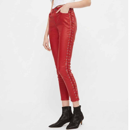 Standing side view highlighting cropped ankle length and metal eyelet side laces on red leather pants