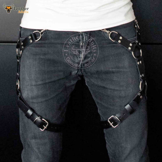 A man wearing a black leather leg harness with stainless steel hardware, designed for BDSM activities.