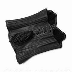 Flat lay detail shot showing the interior dark cotton twill lining and bundled 8-meter lacing cord of the black leather corset.