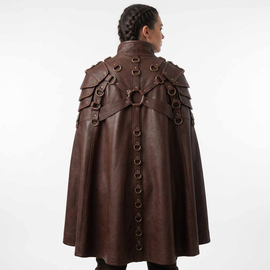 Back view of female model wearing brown leather fantasy warrior cape displaying O ring cross harness and vertical row of metal D rings