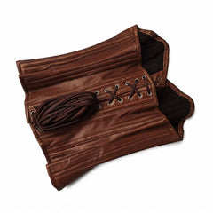 Flat lay detail shot showing the interior dark cotton twill lining and bundled 8-meter lacing cord of the brown leather corset.