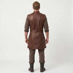 Full length rear studio view of blonde man wearing handcrafted brown leather medieval long jerkin paired with brown trousers and dark leather boots