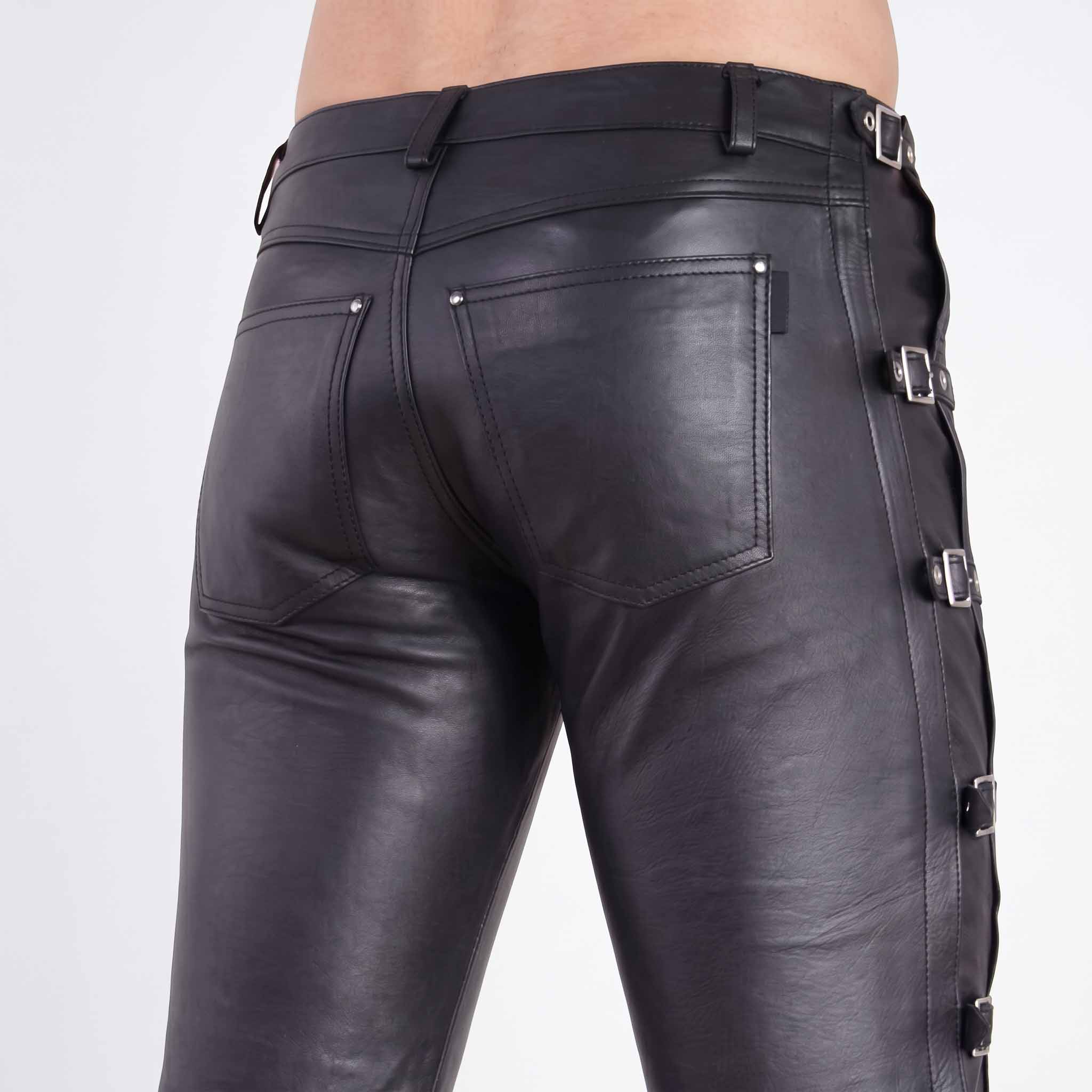 Back close up shot of fitted black leather trousers highlighting riveted rear patch pockets and side waist buckle strap