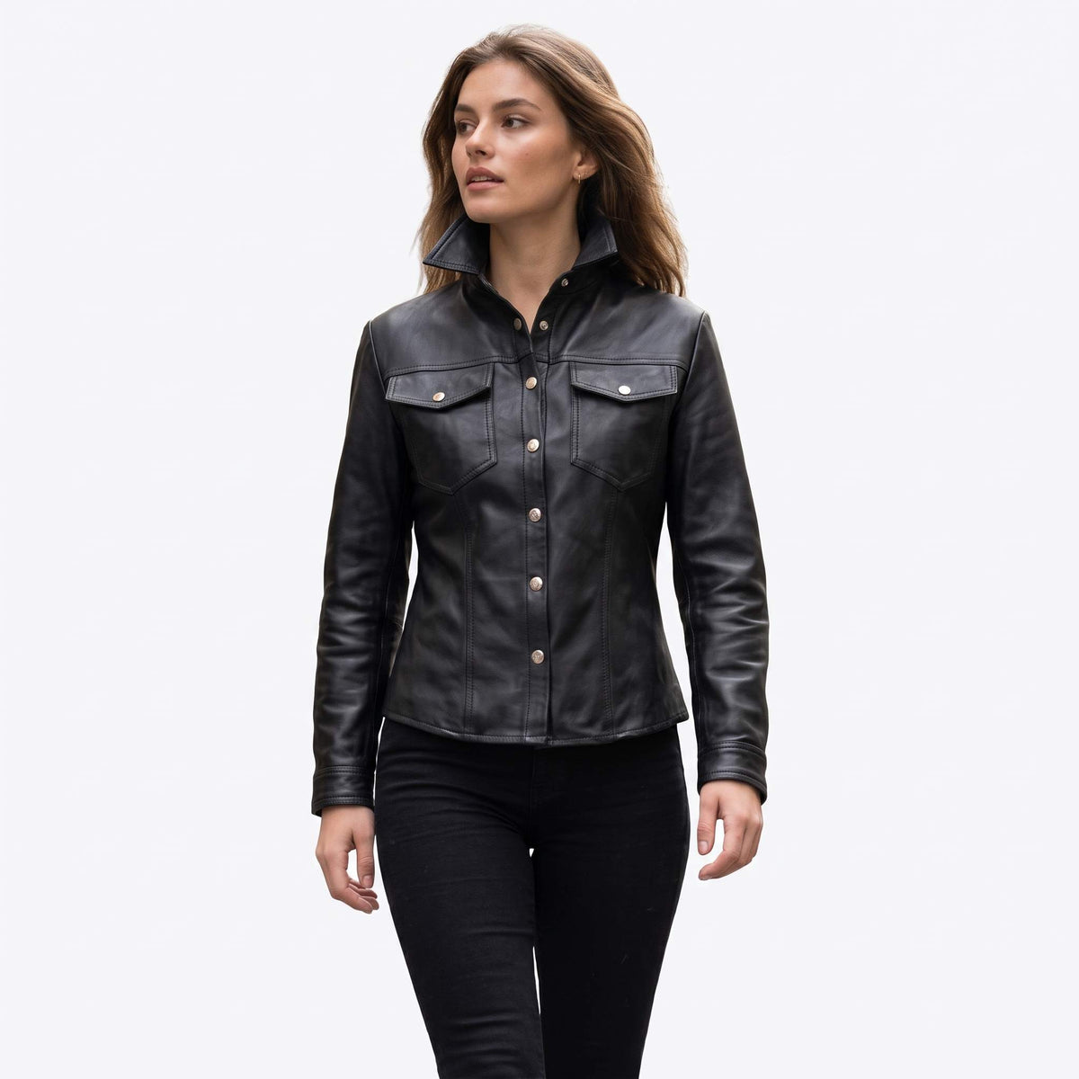 Front view of a woman wearing a tailored black leather shirt jacket with an upright stand collar, silver snap buttons, and chest pockets.