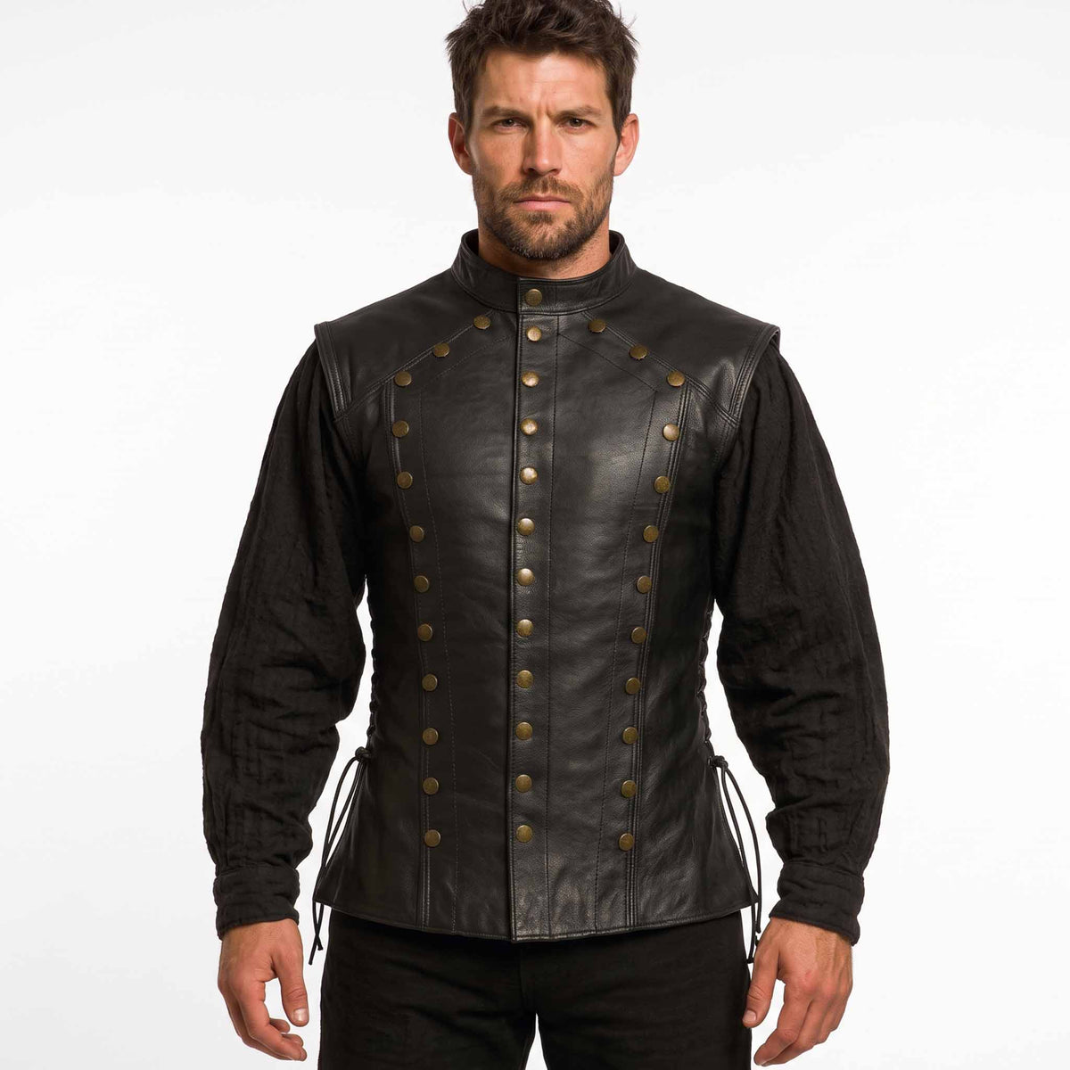 Front view of a man wearing a black handmade leather jerkin vest with brass rivets and a stand collar over a black medieval shirt.