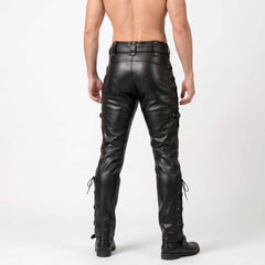 Back studio view of man wearing black genuine leather biker pants showing snap flap rear pockets and calf buckle straps