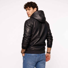 Rear three quarter studio angle of man in black genuine sheepskin leather sweatshirt displaying sleeve gather and hood construction