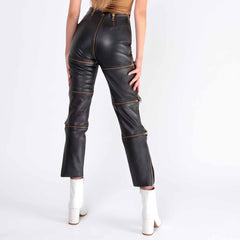 Back view of woman wearing high rise black leather pants displaying full length two way seat zipper and segmented leg panels