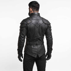 Back view of man modeling black leather steampunk combat coat showing high stand collar, sculpted back yoke, and belted waistline