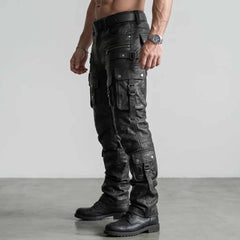 Side profile angle of black leather cargo pants detailing multi-tiered leg flap pockets metal buckles and boot stack hem