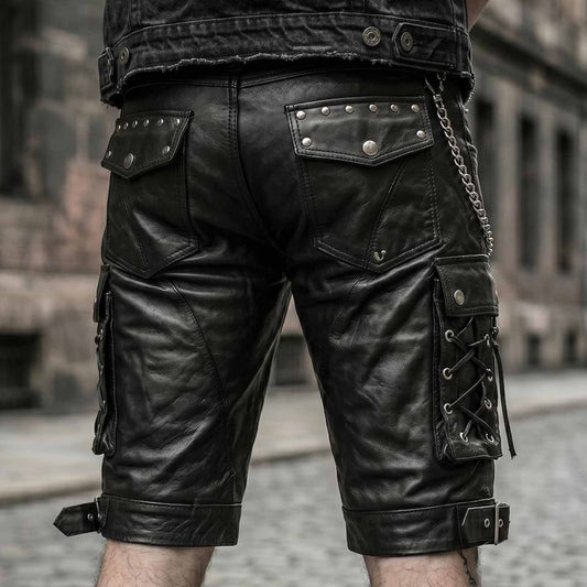 Back view of mens black leather cargo biker shorts showing studded rear flap pockets, side cord lacing, and wallet chain accessory