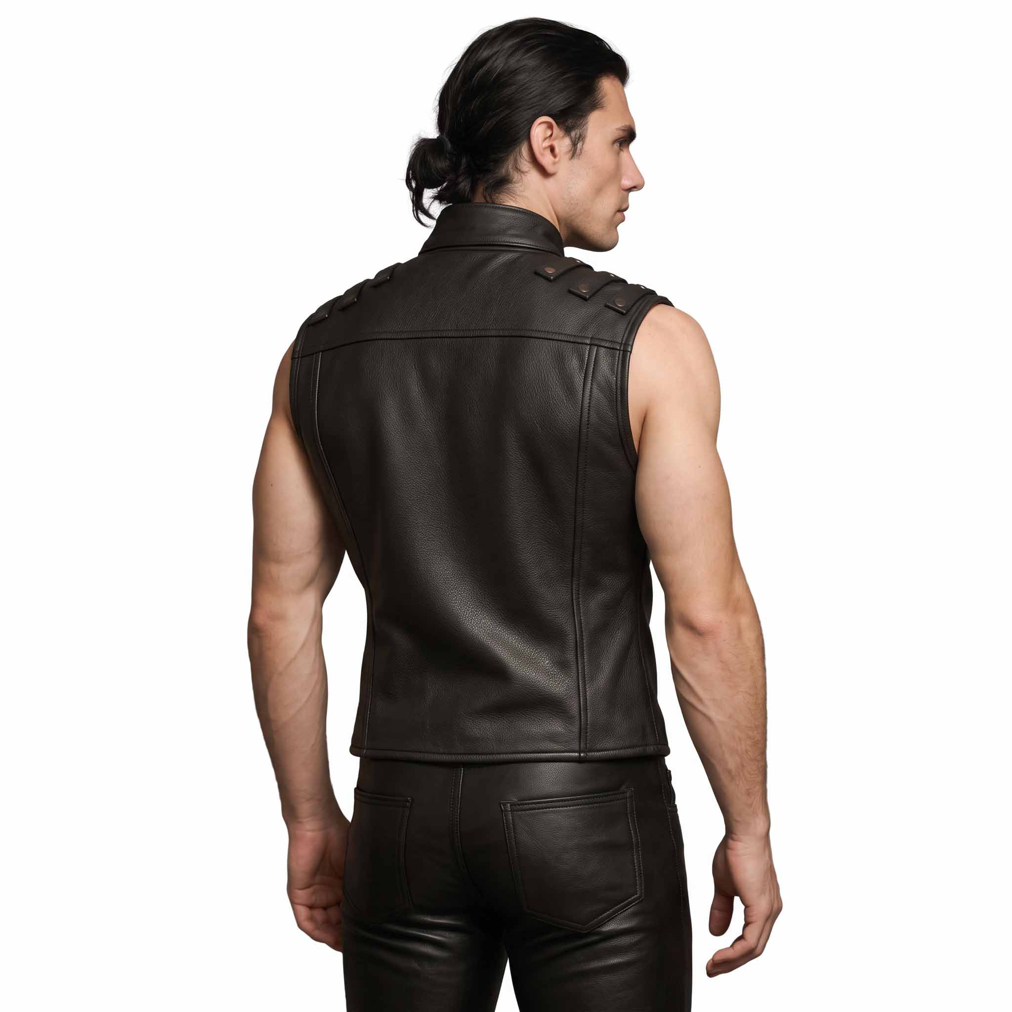 Back angled studio shot of male model wearing handmade black leather vest showing shoulder seam construction and tailored waist drop