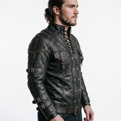 Side profile angle of man modeling black cowhide leather steampunk doublet showing studded shoulder harness bands and multi buckle sleeve straps