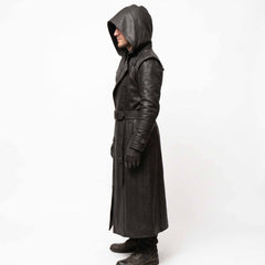 Side profile shot of man modeling full length black leather cyberpunk coat displaying tiered forearm cuff bands and hooded drape