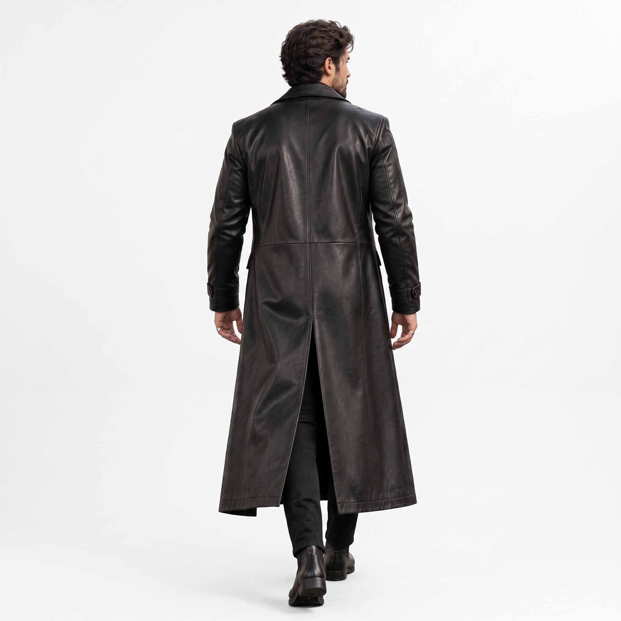 Back full length studio view of mens black leather duster coat showing tailored vertical back seams and deep center split walking vent