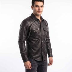 Front three quarter perspective of man modeling black leather gothic punk shirt showing chest zip pocket, hanging D rings, and shoulder chain harness