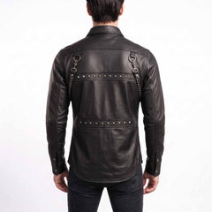 Back view of man wearing black genuine leather rocker shirt displaying dual horizontal panels with pyramid studs and back shoulder D rings with chains