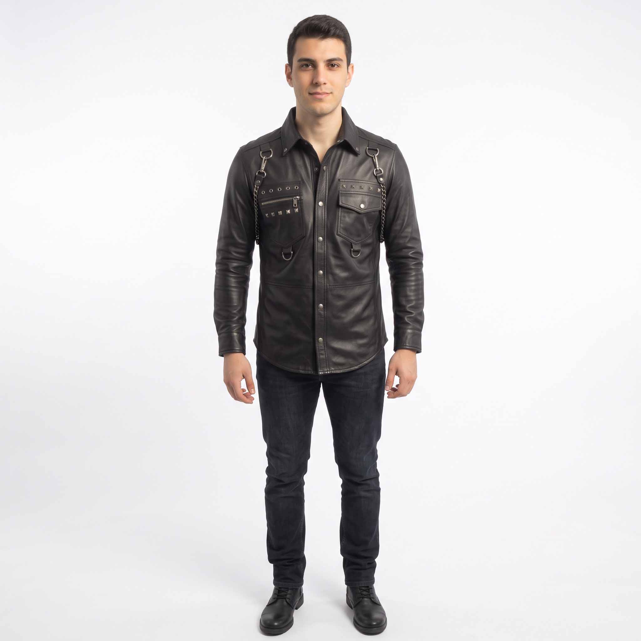Full length studio shot of man wearing handmade black studded leather shirt paired with dark slim jeans and black leather boots