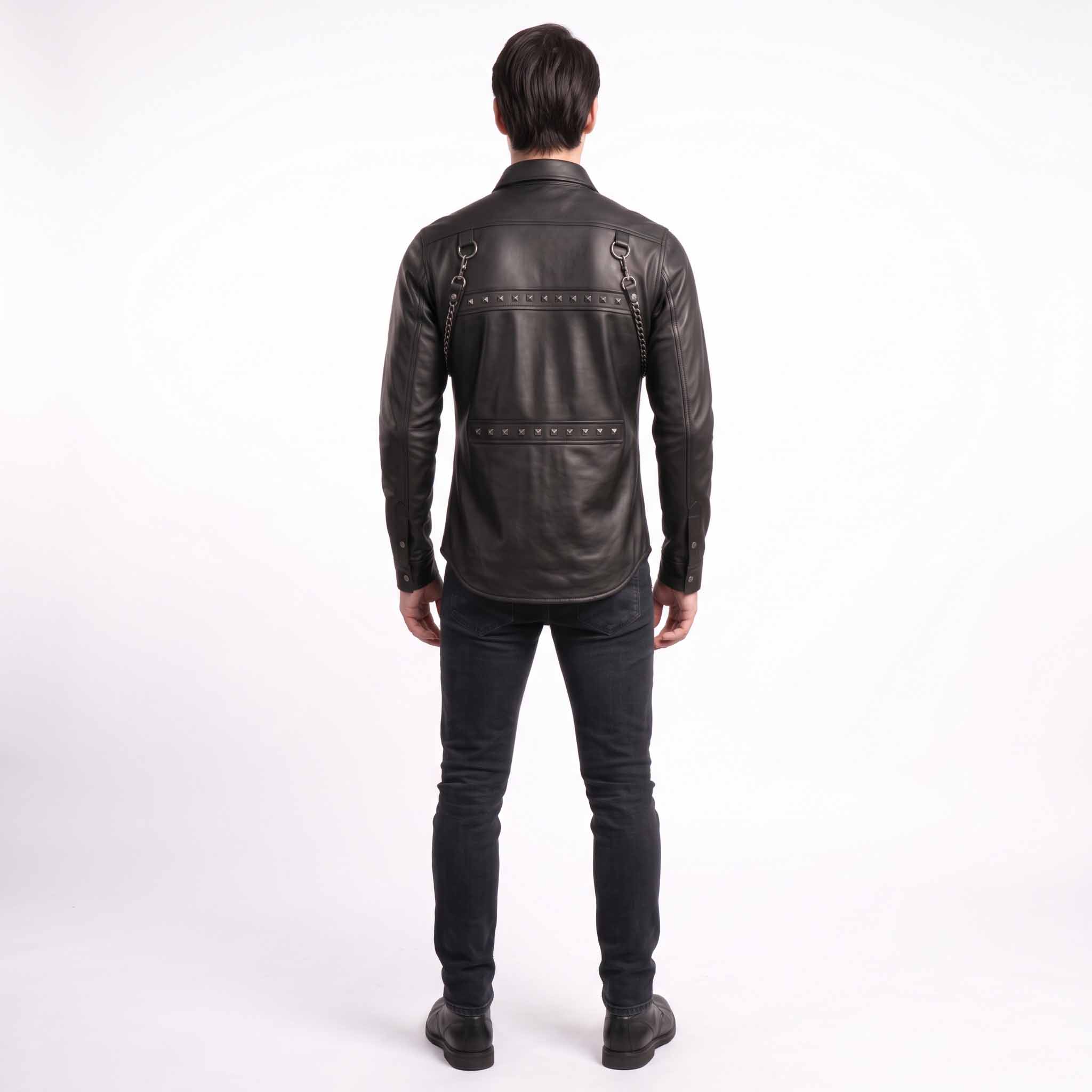 Full length rear studio view of man wearing tailored black leather studded shirt showing curved lower hemline and studded back yoke