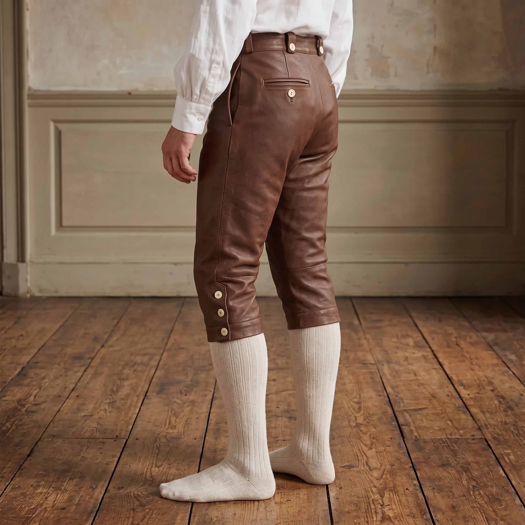 Back three quarter view of mens brown leather historical breeches detailing rear button welt pocket and contoured seat tailoring