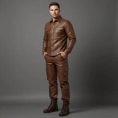 Model posing with hands in pockets showcasing the tailored chest flap pockets and side utility cargo pockets on the men's brown leather set