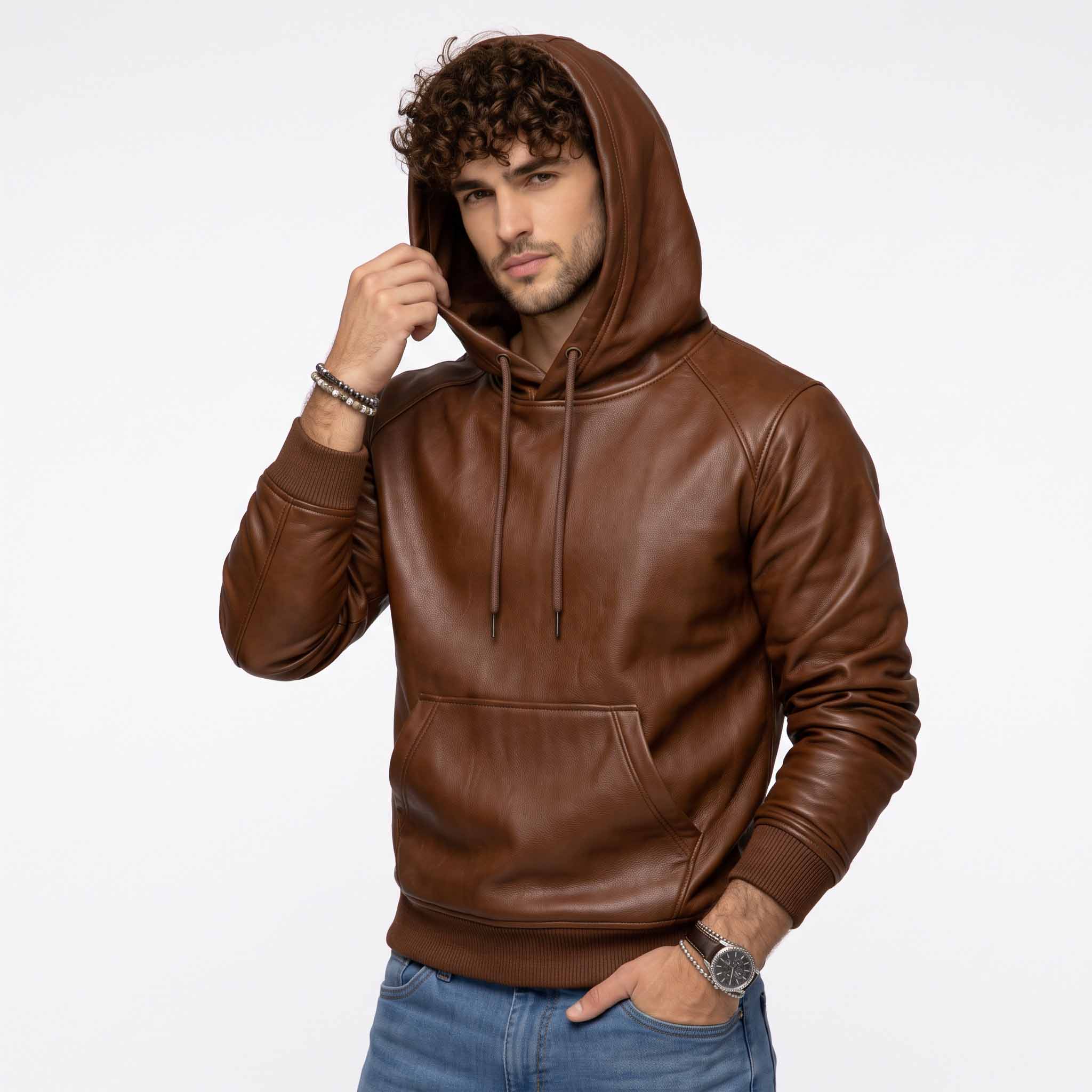 Front three quarter perspective of man modeling brown leather streetwear pullover hoodie adjusting the leather hood