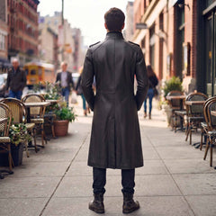 Back full length view of mens black leather victorian duster coat displaying tailored spine seams shoulder straps and center split walking vent