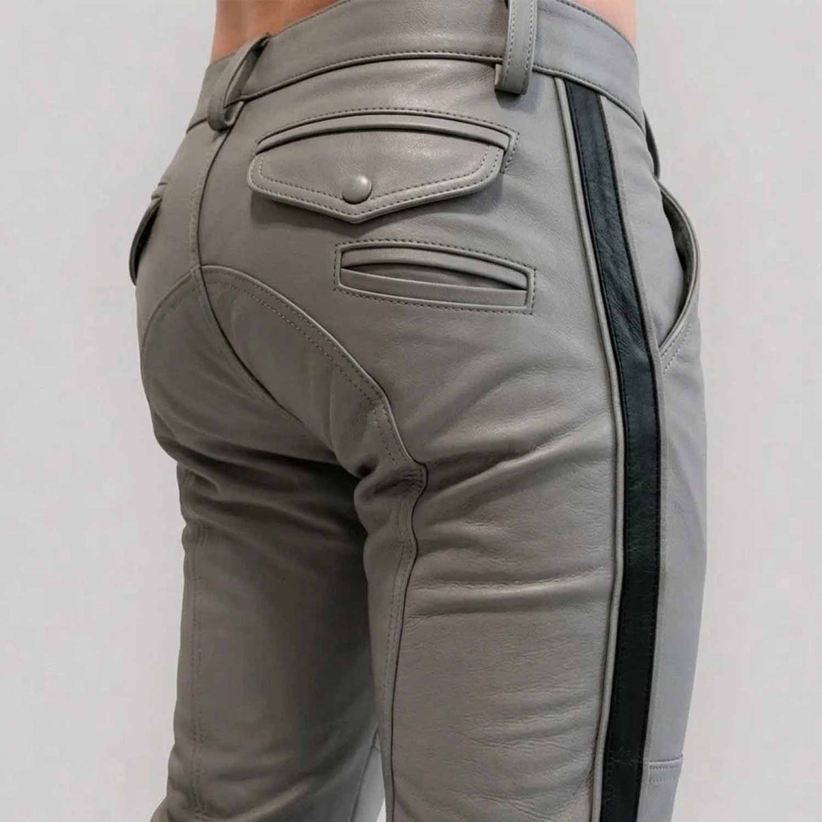 Close-up rear view of a man wearing gray  cowhide leather breeches with a crisp black side stripe, featuring buttoned rear flap pockets and custom paneling.