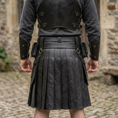 Detailed back view of leather warrior cuirass lower straps and pleated black kilt waistband on stone background