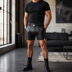 Full-length studio shot of a man wearing black cowhide leather lockable shorts paired with black combat boots and a fitted tee.