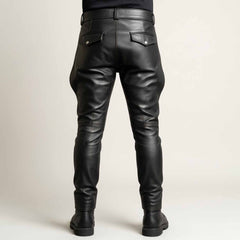 Rear view showcasing the tailored fit, back yoke, and buttoned flap pockets of the men's black leather breeches.