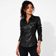 Front view of a brunette model posing in a slim fit black genuine sheep leather shirt with a zip chest pocket and snap button placket.