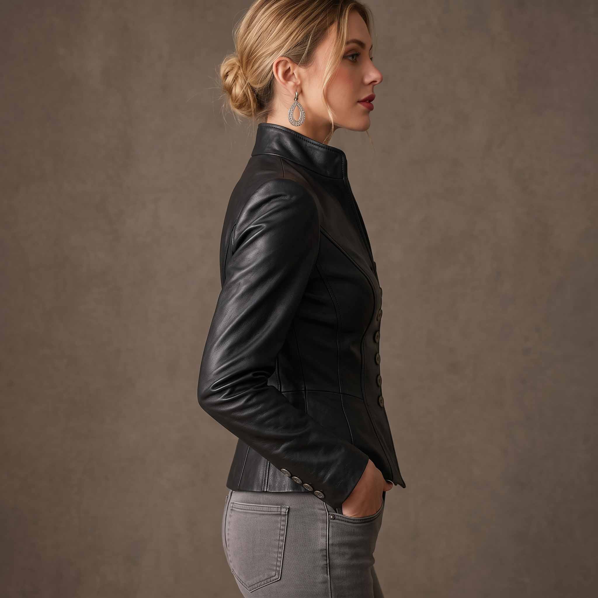 Side profile shot of woman wearing fitted black leather peplum blazer highlighting slim tailored sleeves and waist taper