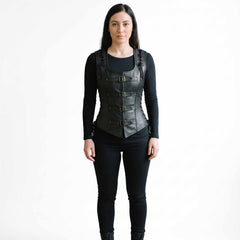 Full length front studio portrait of dark-haired woman in tailored black leather steampunk corset vest and black skinny pants