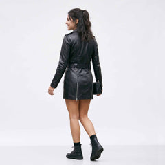 Rear three quarter angle of woman looking over shoulder wearing black leather biker coat dress highlighting tailored back seams