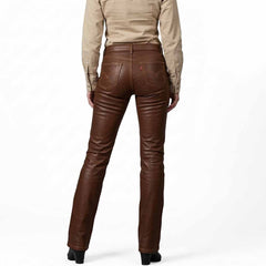 Rear view showcasing the classic five-pocket styling, back yoke, and straight-leg fit of the women's brown leather trousers.