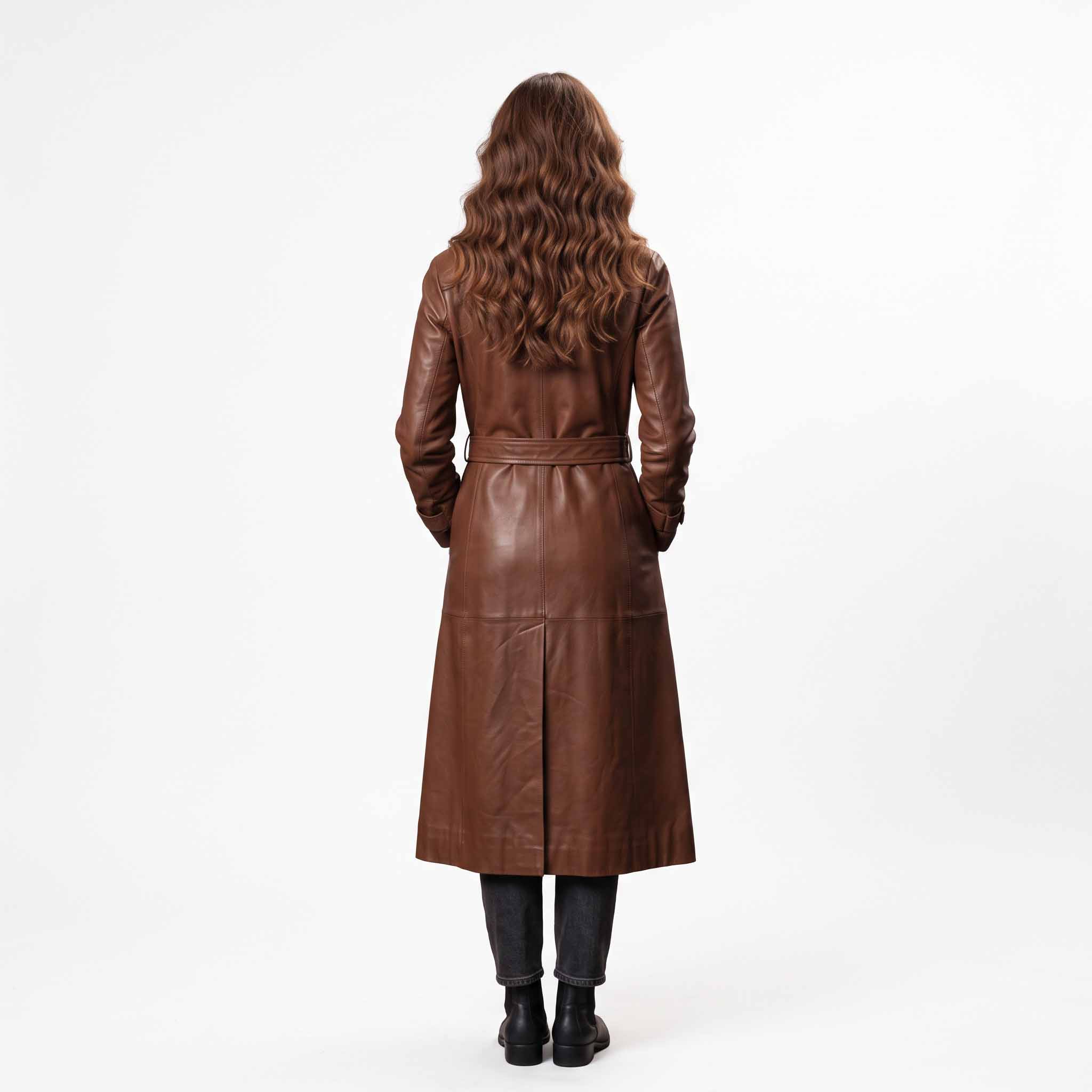 Rear full length studio view of womens brown leather long coat detailing tailored back belt loops and center split walking vent