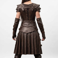 Back view of woman wearing brown leather medieval cosplay dress displaying rear corset cord lacing, shoulder armor straps, and deep rear skirt knife pleats