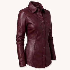 Three quarter front perspective highlighting the spread collar, tailored waistline, and curved hem of a maroon genuine leather top.