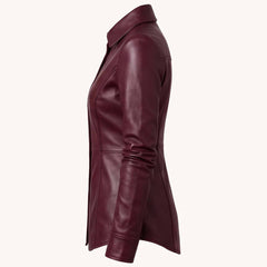 Side profile view showcasing the sleek torso tailoring, long sleeves, and curved bottom edge of a women's deep wine leather overshirt.