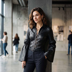 Woman leaning against concrete pillar wearing gothic black leather poet shirt featuring turn down collar and wide trumpet cuffs