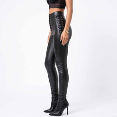 Side profile 90 degree view of female model wearing fitted black leather trousers detailing continuous hip speed lacing and vertical leg seams