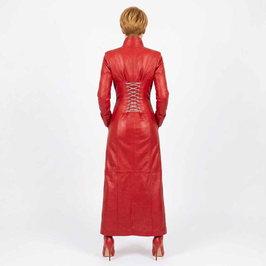 A woman viewed from the back wearing a long red leather dress with long sleeves, a high collar, and a lace-up back, paired with red high heels, against a plain white studio background.