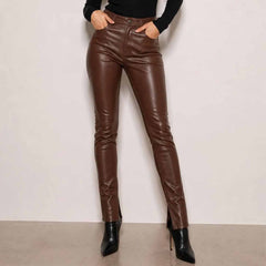 Front view of a woman wearing handmade brown leather trousers with front pockets and a high waist slim fit