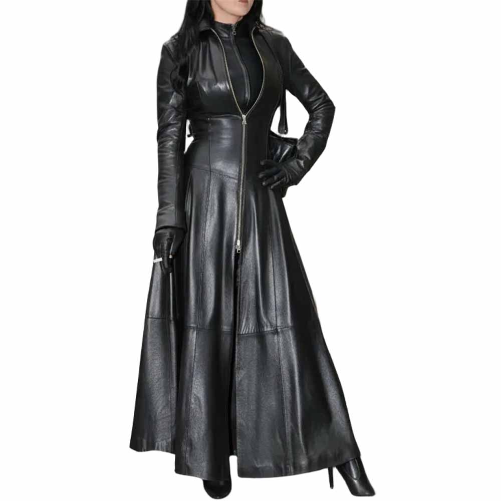 Front view of a woman wearing a long black Nappa leather trench coat featuring a full zipper, high collar, flared skirt, and black leather gloves.