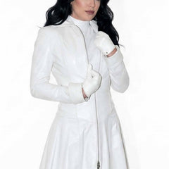 Close-up front view of a white leather trench coat dress highlighting the full front zipper, high stand collar, and white leather gloves.