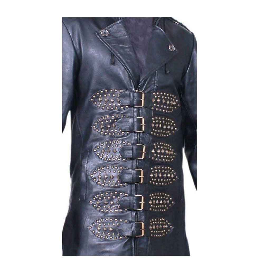 Close-up of brass buckle fasteners on studded leather straps across the front of a men's black antique cowhide trench coat.