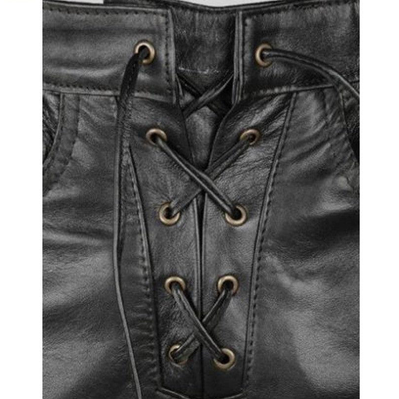 Close-up of a black leather garment with a lace-up front, showing the stitching, eyelets, and laces. A Leather Addict logo is visible in the top-left corner.